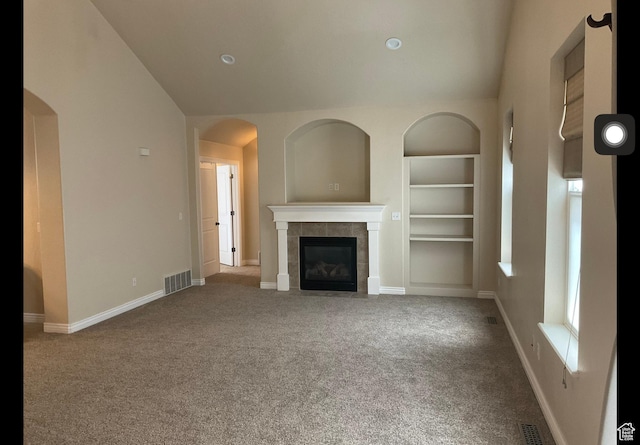 2843 W Pine Cone Ln N, Lehi, UT 84043 - unfurnished living room with a tiled fireplace, visible vents, built in shelves, and lofted ceiling