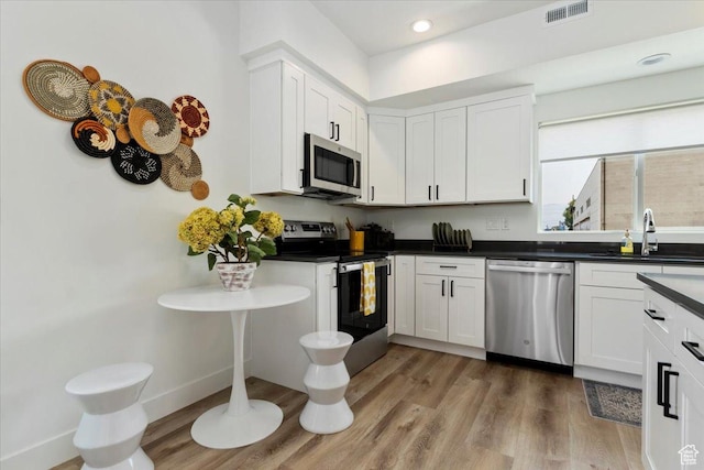 971 W 1700 S Unit 114, Salt Lake City, UT 84104 - kitchen featuring light wood-type flooring, visible vents, a sink, stainless steel appliances, and white cabinets