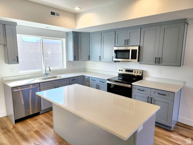 971 W 1700 S Unit 114, Salt Lake City, UT 84104 - kitchen featuring light wood finished floors, visible vents, gray cabinets, stainless steel appliances, and a sink