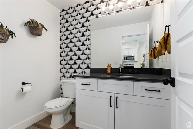 971 W 1700 S Unit 114, Salt Lake City, UT 84104 - half bathroom featuring baseboards, toilet, wood finished floors, and vanity