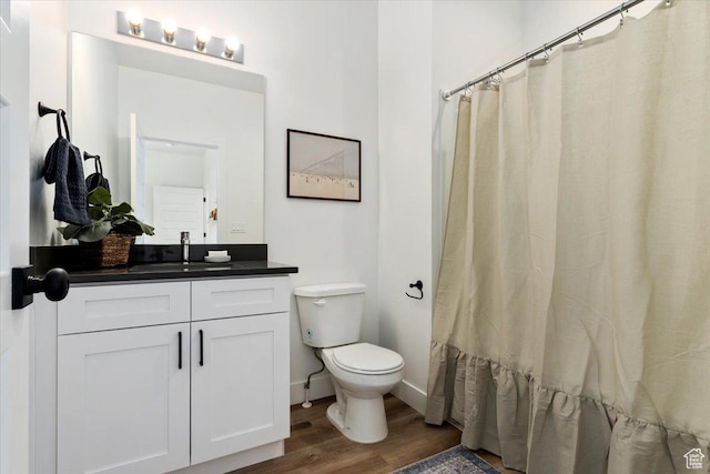 971 W 1700 S Unit 114, Salt Lake City, UT 84104 - full bathroom featuring baseboards, toilet, a shower with curtain, wood finished floors, and vanity