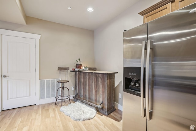kitchen with light wood-style flooring, baseboards, visible vents, recessed lighting, and stainless steel fridge with ice dispenser