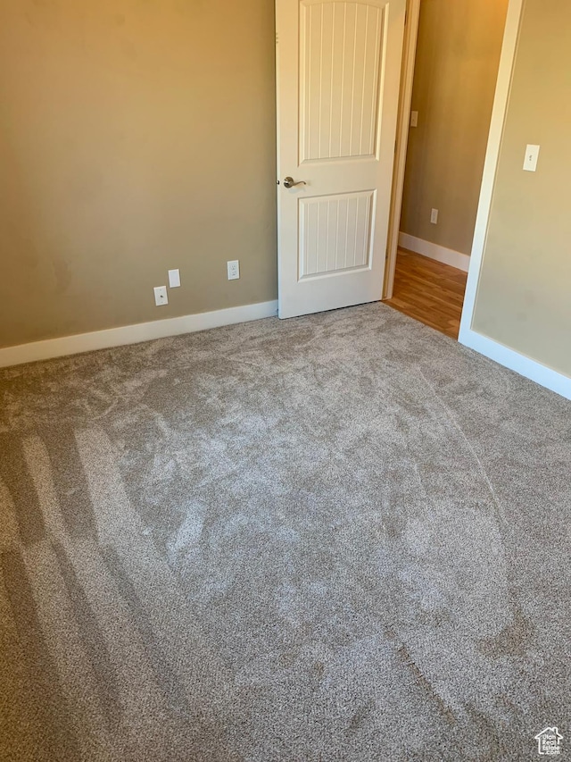 carpeted empty room featuring baseboards