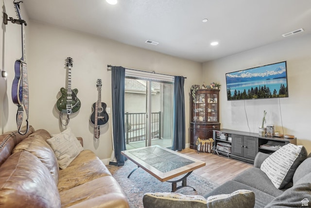 living area with recessed lighting, visible vents, light wood finished floors, and baseboards