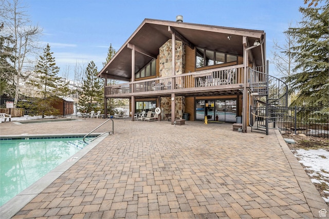 2025 Canyons Resort Dr Unit R8, Park City, UT 84060 - rear view of property with fence, stairs, an outdoor structure, a community pool, and a patio