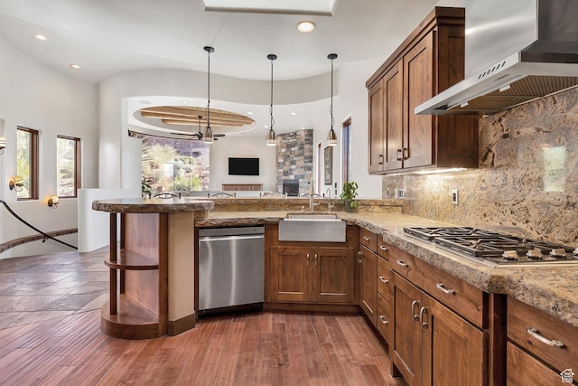 2336 W Entrada Trl Unit 44, St George, UT 84770 - kitchen with appliances with stainless steel finishes, wall chimney exhaust hood, a sink, recessed lighting, and a peninsula