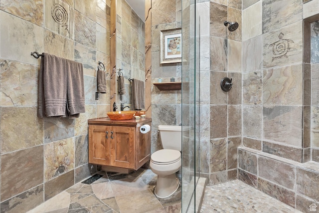 2336 W Entrada Trl Unit 44, St George, UT 84770 - bathroom featuring tile walls, a tile shower, toilet, vanity, and stone finish floors
