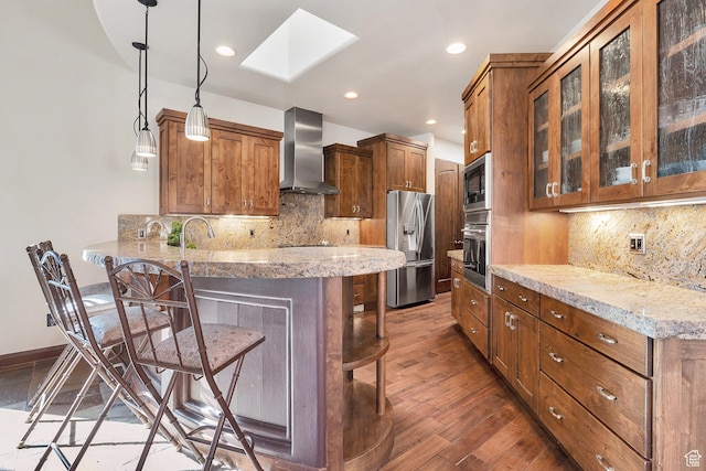 2336 W Entrada Trl Unit 44, St George, UT 84770 - kitchen with wall chimney range hood, stainless steel appliances, a skylight, a kitchen bar, and a peninsula
