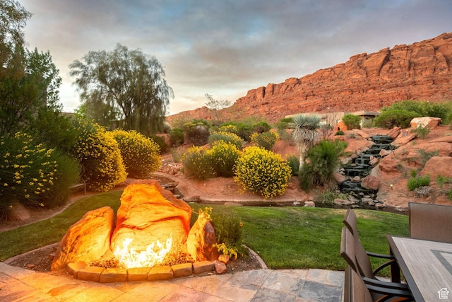 2336 W Entrada Trl Unit 44, St George, UT 84770 - view of grassy yard featuring an outdoor fire pit and a mountain view