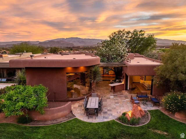 2336 W Entrada Trl Unit 44, St George, UT 84770 - rear view of property featuring stucco siding, a patio, a mountain view, an outdoor hangout area, and a lawn