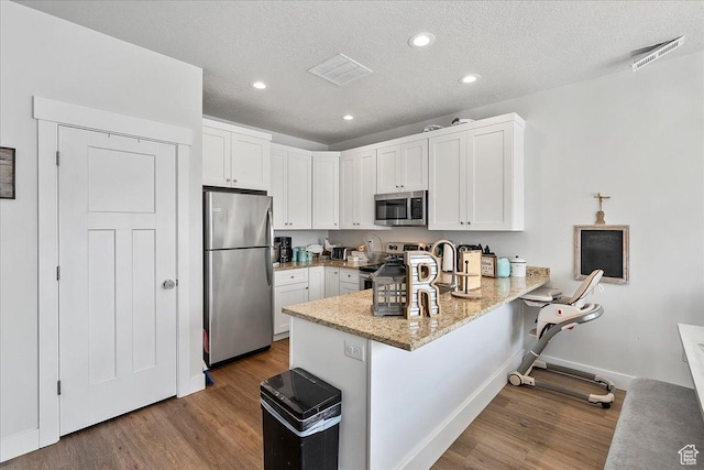 292 N 100 W, Morgan, UT 84050 - kitchen with visible vents, appliances with stainless steel finishes, a peninsula, and white cabinets
