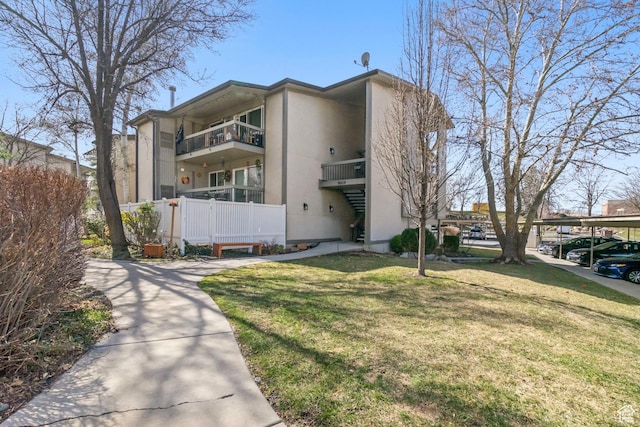 view of front of house featuring stucco siding and a front yard
