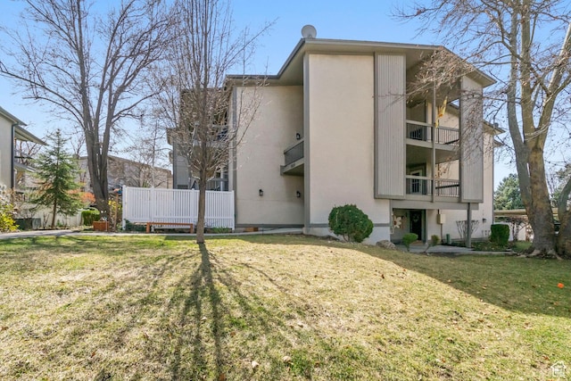 5809 S Waterbury Dr Unit D, Murray, UT 84121 - back of property featuring stucco siding and a lawn