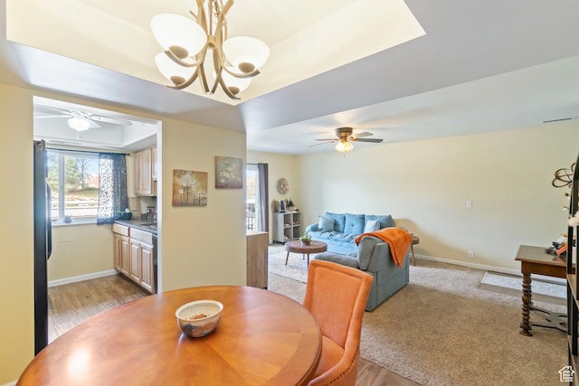 5809 S Waterbury Dr Unit D, Murray, UT 84121 - dining room with a tray ceiling, baseboards, light carpet, and ceiling fan with notable chandelier