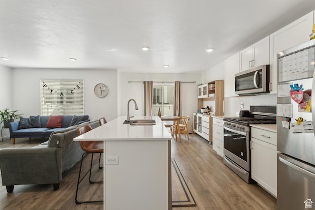 1722 E Muss Dr, Eagle Mountain, UT 84005 - kitchen with wood finished floors, a sink, appliances with stainless steel finishes, a kitchen bar, and open floor plan