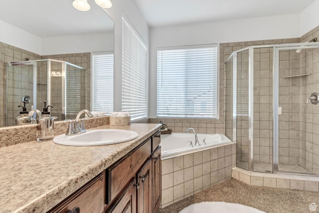 full bath with a stall shower, vanity, and a bath