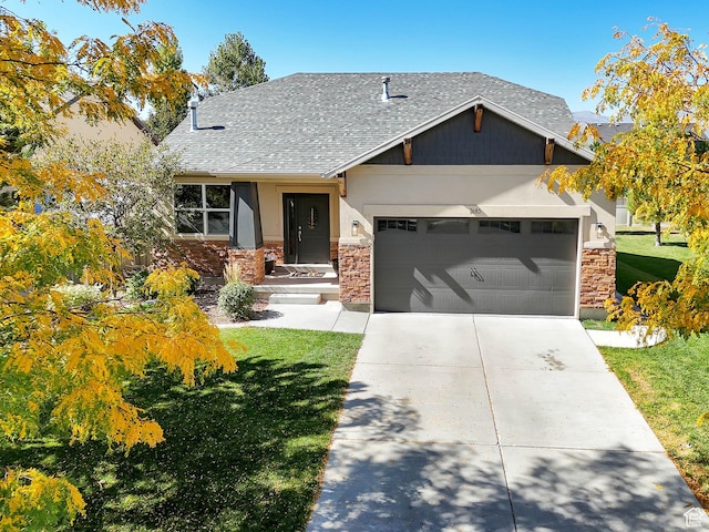 view of front of property with a shingled roof, a garage, driveway, and a front lawn