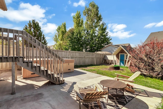 view of patio with a shed, a fenced backyard, and an outdoor structure