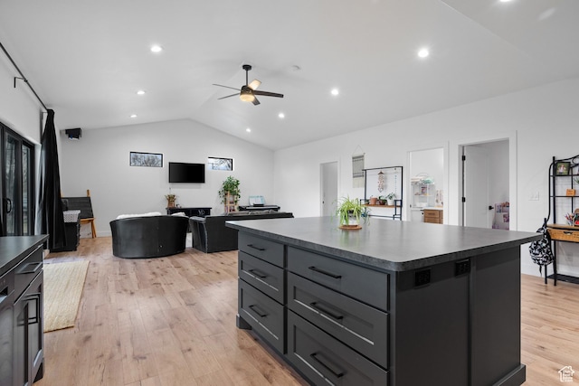 2386 N 3900 W, Corinne, UT 84307 - kitchen with dark countertops, a kitchen island, ceiling fan, light wood-type flooring, and vaulted ceiling