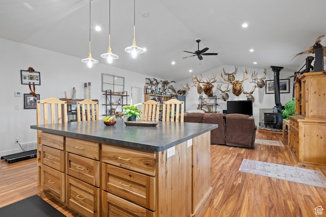 2386 N 3900 W, Corinne, UT 84307 - kitchen with dark countertops, ceiling fan, lofted ceiling, a wood stove, and light wood-style floors
