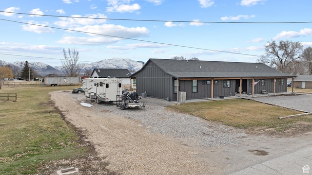 2386 N 3900 W, Corinne, UT 84307 - view of front of house featuring board and batten siding, gravel driveway, a front lawn, a porch, and a mountain view