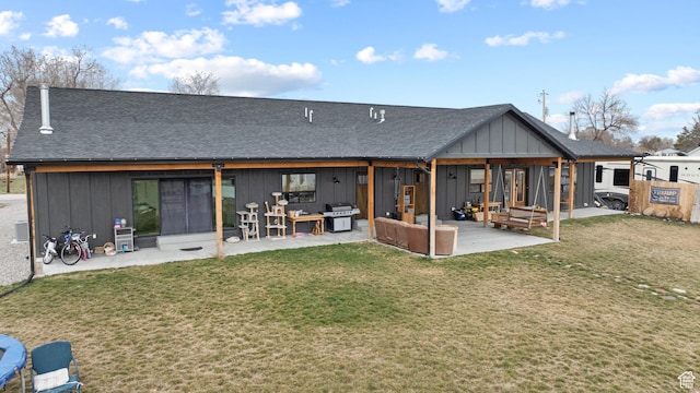 2386 N 3900 W, Corinne, UT 84307 - back of house with a patio, a shingled roof, a lawn, board and batten siding, and an outdoor hangout area