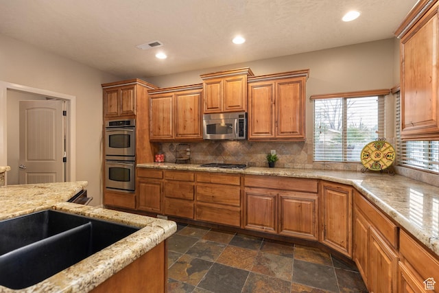 1815 N Red Mountain Dr, Santa Clara, UT 84765 - kitchen featuring light stone counters, recessed lighting, appliances with stainless steel finishes, brown cabinets, and backsplash
