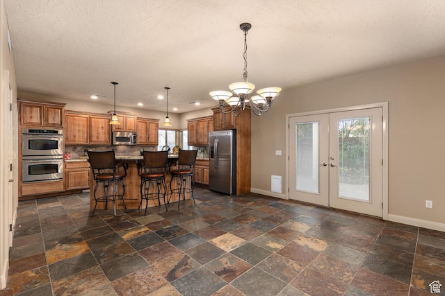 1815 N Red Mountain Dr, Santa Clara, UT 84765 - kitchen featuring baseboards, a chandelier, brown cabinets, appliances with stainless steel finishes, and french doors