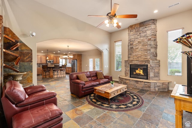 1815 N Red Mountain Dr, Santa Clara, UT 84765 - living area featuring visible vents, stone tile floors, ceiling fan with notable chandelier, a fireplace, and arched walkways
