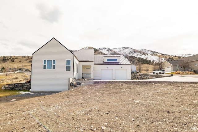 1959 E Deer Crest Cir N, Logan, UT 84341 - exterior space featuring a garage, driveway, metal roof, and a mountain view