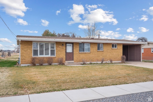 ranch-style house with brick siding, concrete driveway, a front lawn, and a carport