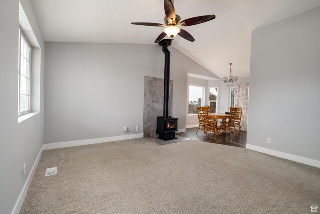 46501 W Bandanna Dr, Fruitland, UT 84027 - unfurnished living room featuring visible vents, lofted ceiling, carpet flooring, baseboards, and a wood stove