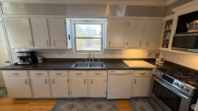82 W 500 N, Vernal, UT 84078 - kitchen with backsplash, a sink, dark countertops, light wood-style floors, and appliances with stainless steel finishes