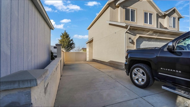 5254 W Ted Way, West Valley City, UT 84120 - view of side of home with stucco siding, an attached garage, and fence