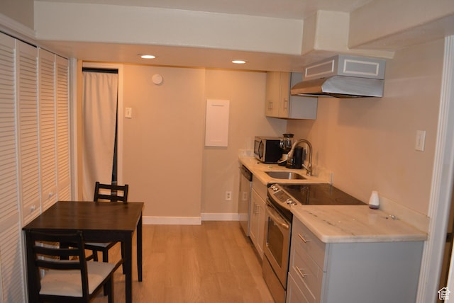 4023 W Severn Cir S, Jordan, UT 84009 - kitchen featuring stainless steel appliances, under cabinet range hood, light wood-style flooring, a sink, and light stone countertops