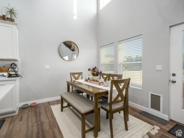 4268 S Steele Creek Ct E, Millcreek, UT 84107 - dining area featuring light wood-type flooring, baseboards, a towering ceiling, and heating unit