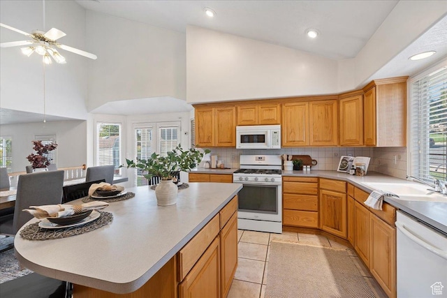 965 E 3400 N, Layton, UT 84040 - kitchen with a healthy amount of sunlight, light countertops, decorative backsplash, white appliances, and a ceiling fan