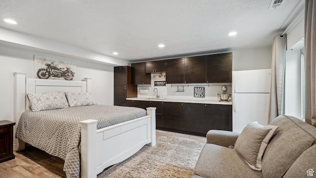 125 N 1430 E, Spanish Fork, UT 84660 - bedroom with light wood-type flooring, bar with sink, freestanding refrigerator, and recessed lighting
