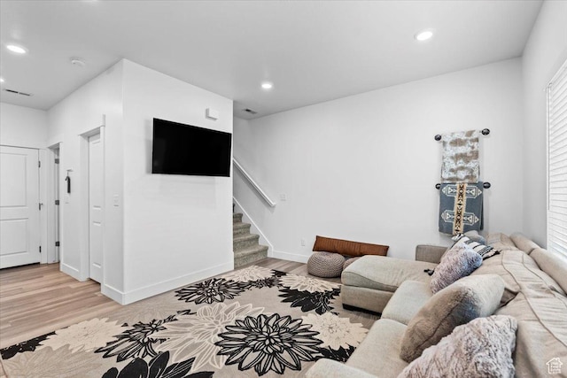 living area with stairway, visible vents, baseboards, light wood-style flooring, and recessed lighting