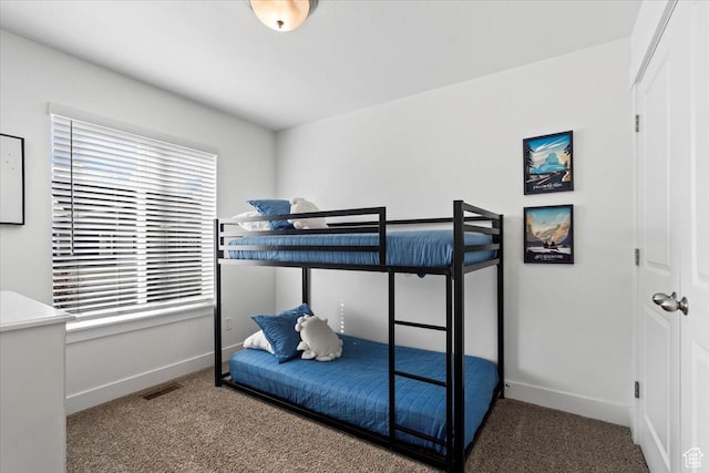 carpeted bedroom featuring visible vents, multiple windows, and baseboards