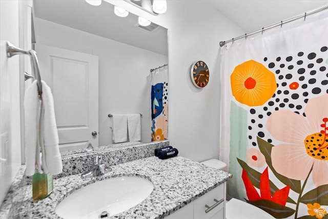 full bathroom featuring vanity, toilet, and visible vents