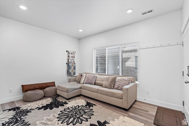 living room with visible vents, recessed lighting, light wood-type flooring, and baseboards