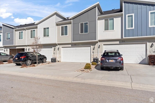 view of property with a garage, stone siding, board and batten siding, and concrete driveway