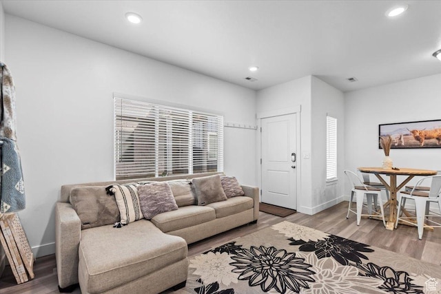 living room with visible vents, recessed lighting, baseboards, and wood finished floors