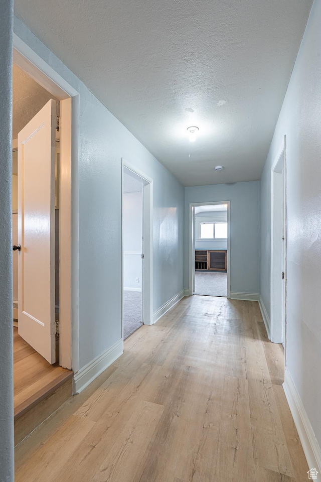 33 N 200 E, Logan, UT 84321 - hallway with baseboards, light wood-style floors, and a textured ceiling