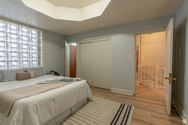 33 N 200 E, Logan, UT 84321 - bedroom with baseboards, a closet, light wood-style flooring, and a textured ceiling