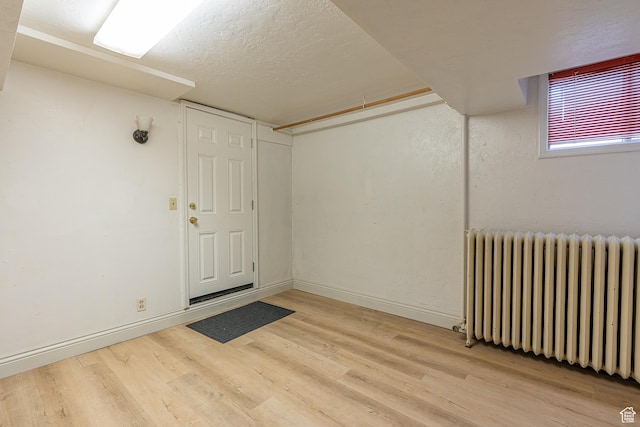 33 N 200 E, Logan, UT 84321 - interior space with baseboards, a textured ceiling, radiator heating unit, and light wood finished floors