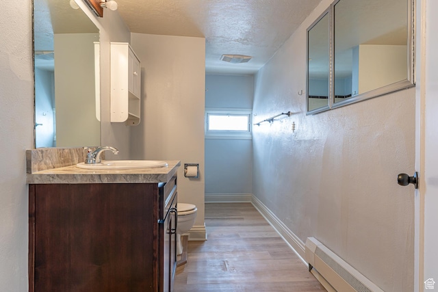 33 N 200 E, Logan, UT 84321 - bathroom with a textured ceiling, baseboards, wood finished floors, vanity, and baseboard heating
