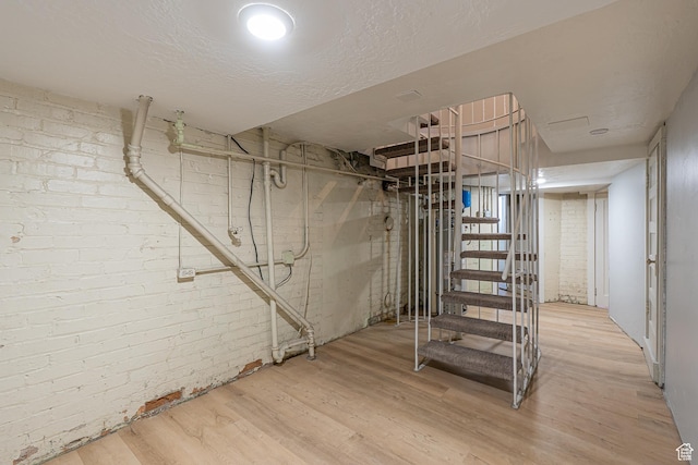 33 N 200 E, Logan, UT 84321 - below grade area with stairs, wood finished floors, brick wall, and a textured ceiling