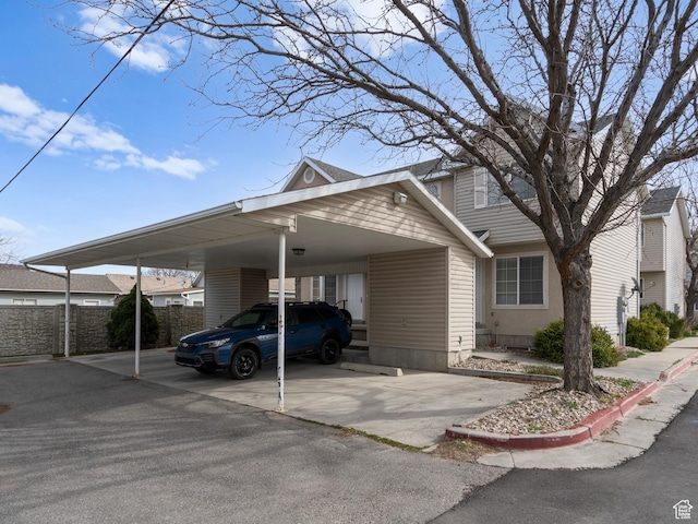 view of front of home with a carport and fence